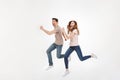 Full-length photo of energetic couple man and woman in casual t-shirt running and smiling on camera with happy look, isolated Royalty Free Stock Photo
