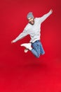 Full length photo of energetic man smiling and jumping isolated over red background Royalty Free Stock Photo