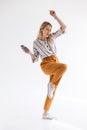 Full length photo of european woman dancing and holding mobile phone while listening to music via bluetooth earpod