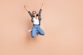 Full length photo of excited cool woman wear khaki shirt rising fists jumping high emtpy space isolated beige color Royalty Free Stock Photo