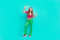 Full length photo of excited cute schoolgirl wear pink crop top flared pants dancing having fun isolated turquoise color