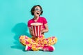 Full length photo of excited cute woman dressed flower print trousers enjoying films pop corn empty space  teal Royalty Free Stock Photo