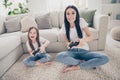 Full length photo of excited energetic mommy small kid sit legs crossed carpet play video game want win wear white t