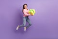 Full length photo of excited funny lady dressed strawberry cardigan jumping holding gift empty space isolated purple