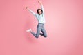 Full length photo of excited lady raise fists jumping high celebrate victory wear blue pullover jeans isolated pink Royalty Free Stock Photo