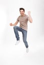 Full-length photo of excited man 30s in casual t-shirt and jeans Royalty Free Stock Photo