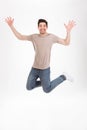 Full-length photo of excited man 30s in casual t-shirt and jeans Royalty Free Stock Photo