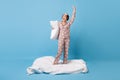 Full length photo of excited nice lady raise hand hold pillow stank blanket isolated on blue color background
