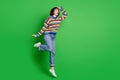 Full length photo excited shiny lady dressed pullover jumping high arm forehead looking far empty space isolated green