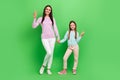 Full length photo of friendly pretty little girl mom dressed casual clothes showing v-signs  green color Royalty Free Stock Photo