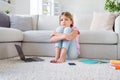 Full length photo of frustrated girl sit floor carpet miss friends study remote corona virus quarantine in house indoors