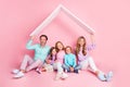 Full length photo full family daddy mommy and three small kids sit floor hold paper card roof new big house isolated Royalty Free Stock Photo