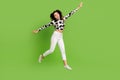 Full length photo of funky carefree girl dressed cowskin top jumping high arms sides flying isolated green color Royalty Free Stock Photo