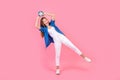Full length photo of funky carefree girl wear blue shirt having fun rising classic clock isolated pink color background