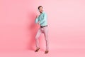 Full length photo of funky cheerful young man dance song listen wear headphones isolated on pastel pink color background