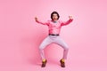 Full length photo of funky handsome brunet hair guy dancing imagining himself bike isolated pink color background