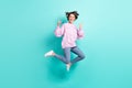 Full length photo of funky rude young woman wear violet sweater jumping showing hard rock sign isolated turquoise color Royalty Free Stock Photo