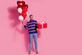 Full length photo of funky thoughtful man wear sweater rising present box heart balloons looking empty space isolated Royalty Free Stock Photo