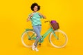 Full length photo of funky young lady near bicycle thumb up wear t-shirt jeans sneakers bag isolated on yellow Royalty Free Stock Photo