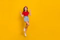 Full length photo of funny little girl jump show v-sign wear red t-shirt hairband jeans skirt footwear isolated on Royalty Free Stock Photo