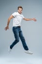 Full-length photo of funny man in casual t-shirt, blazer and jeans running or jumping in air isolated over gray Royalty Free Stock Photo