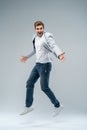 Full-length photo of funny man in casual t-shirt, blazer and jeans running or jumping in air isolated over gray Royalty Free Stock Photo