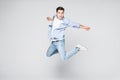 Full-length photo of funny man in casual t-shirt and jeans running or jumping in air isolated over white background Royalty Free Stock Photo