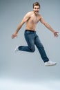 Full-length photo of funny man running or jumping in air isolated over gray background. Royalty Free Stock Photo