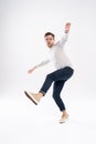 Full-length photo of funny man 30s in casual t-shirt and jeans jumping isolated over white background. Royalty Free Stock Photo