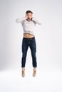Full-length photo of funny man 30s in casual t-shirt and jeans jumping isolated over white background. Royalty Free Stock Photo