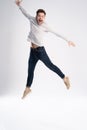 Full-length photo of funny man 30s in casual t-shirt and jeans jumping isolated over white background. Royalty Free Stock Photo