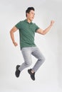 Full-length photo of funny man 30s in casual t-shirt and jeans running or jumping in air isolated over white background Royalty Free Stock Photo