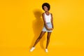 Full length photo of girl shy poselook empty space wear white tank top isolated yellow color background Royalty Free Stock Photo