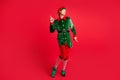 Full length photo of handsome x-mas north-pole jolly elf dance wear x-mas costume isolated red bright color background Royalty Free Stock Photo