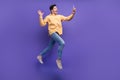 Full length photo of handsome young guy selfie photo wave hand running dressed stylish yellow garment isolated on purple Royalty Free Stock Photo