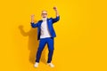 Full length photo of happy cheerful old man raise fists winner wear blue tuxedo isolated on yellow color background Royalty Free Stock Photo