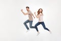 Full-length photo of happy couple man and woman in casual t-shirt running and smiling on camera with joyful look, isolated over w Royalty Free Stock Photo