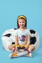 Girl sitting on bean bag chair, holding joystick and playing video game Royalty Free Stock Photo