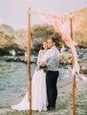 The full-length photo of the happy newlyweds watching the sunset in the sea. Royalty Free Stock Photo