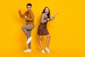 Full length photo of happy victorious young man and woman raise fists winner isolated on yellow color background