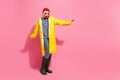 Full length photo of impressed funky woman dressed rain coat walking empty space isolated pink color background