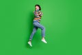 Full length photo impressed funny lady dressed colorful pullover jumping arms cheeks looking empty space isolated green