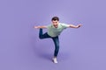 Full length photo of impressed overjoyed man stand on foot leg imagine can fly dream travel abroad isolated on purple Royalty Free Stock Photo