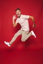 Full length photo of joyful man in striped t-shirt jumping and s