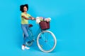 Full length photo of little funny positive cheerful smiling lady teenager hold her bicycle busket with flowers delivery Royalty Free Stock Photo