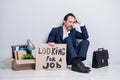 Full length photo of loser worker mature aged guy jobless man hold placard need work sit floor briefcase belongings box Royalty Free Stock Photo