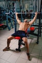 A sports guy doing exercise with a big barbell on a bright gym background. A bodybuilder training in a fitness club. Royalty Free Stock Photo