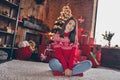 Full length photo of nice millennial lady sit on floor wear new year sweater jeans socks at home alone on christmas eve