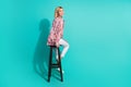 Full length photo of nice young lady sit chair back turn around wear trendy pink print garment on cyan color