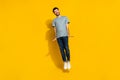 Full length photo of optimistic man dressed denim clothes imagine can fly like butterfly empty space isolated on yellow Royalty Free Stock Photo